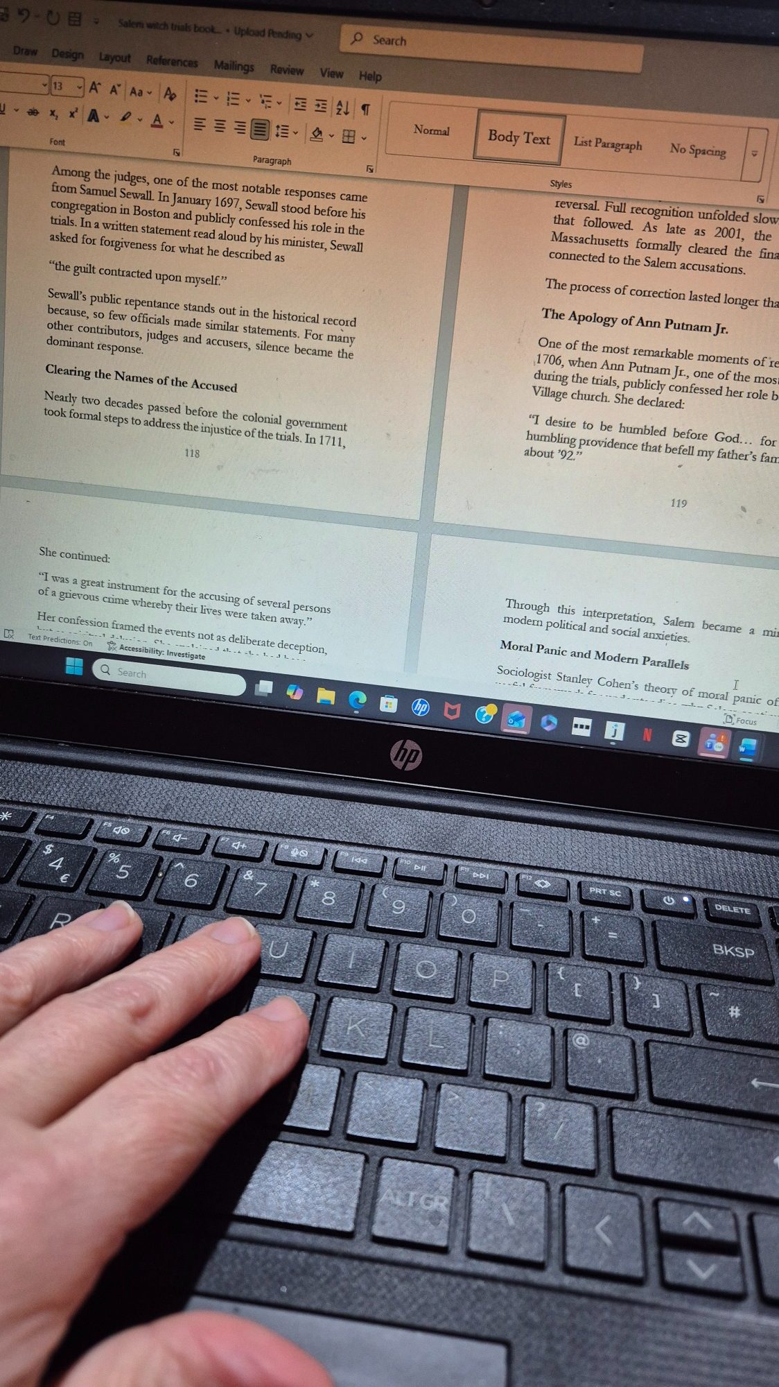 hand posed to write on an open laptop